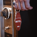 GIF d'une main tenant le porte-clé "Motel" de Just A Little Fun près d'une serrure de porte